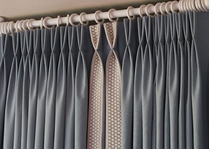 Photo d'un rideaux sur mesure gris avec plis flamands
