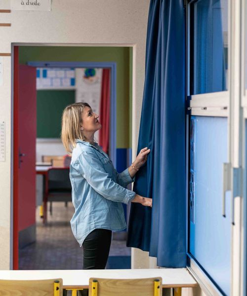 Décoratrice d'intérieur qui inspecte les rideaux d'une école 